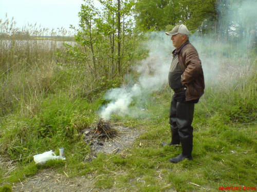 Ogrzewający się przy ognisku - Janusz Dudzik.